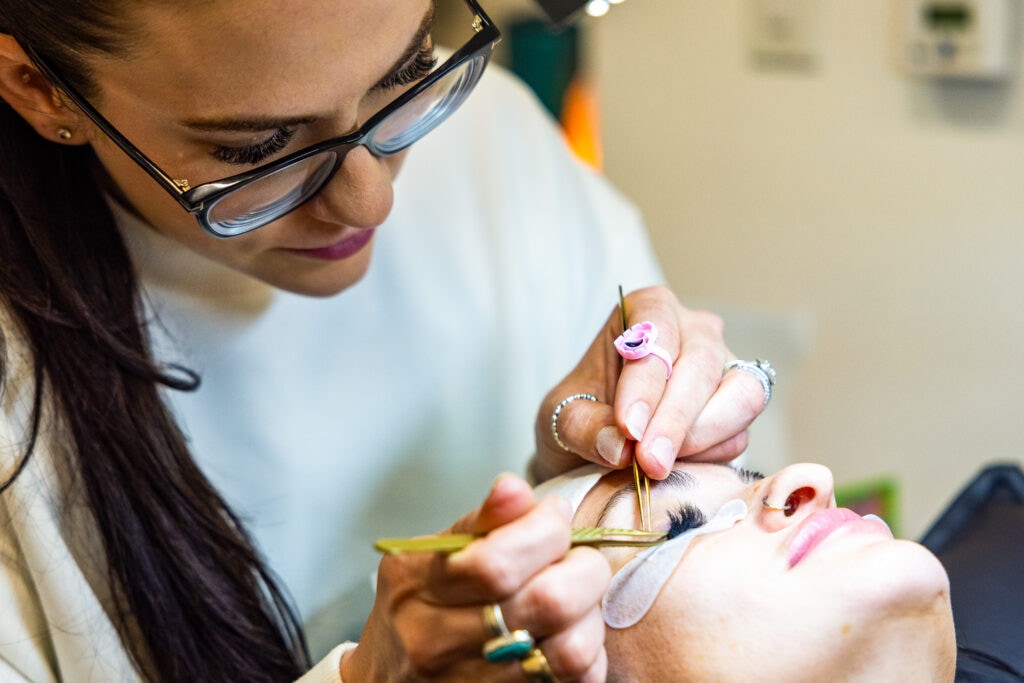 Eyelash extension application by beautician.