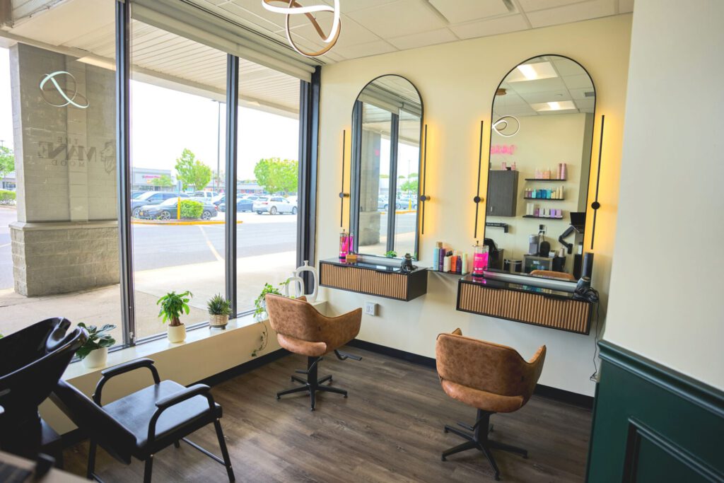 Modern hair salon with stylish chairs and mirrors.