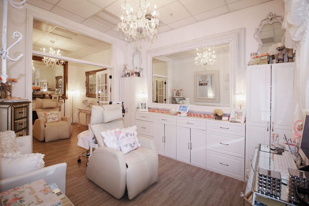 Elegant salon interior with plush chairs and chandeliers.