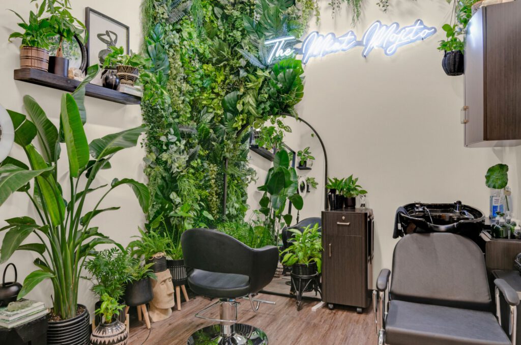 Plant-filled salon with chairs and stylish decor.