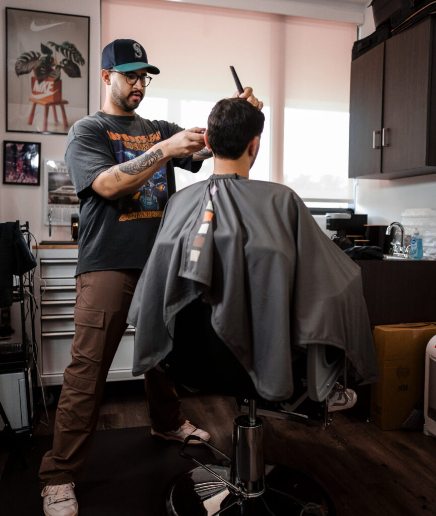 Barber giving a haircut in a modern barbershop.