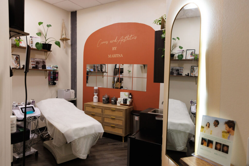 Cozy spa room with treatment bed and decor.