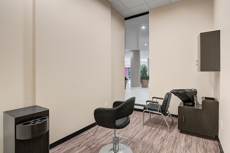 Modern hair salon interior with chairs and sink.