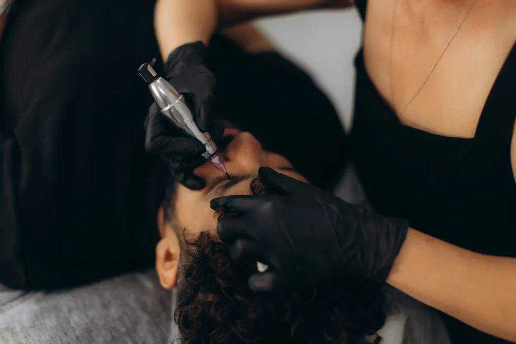 Tattoo artist working on client's eyebrow