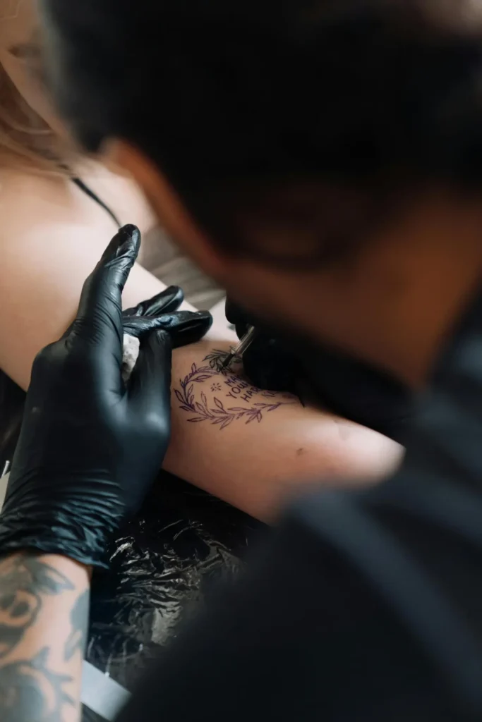 Tattoo artist working on arm design