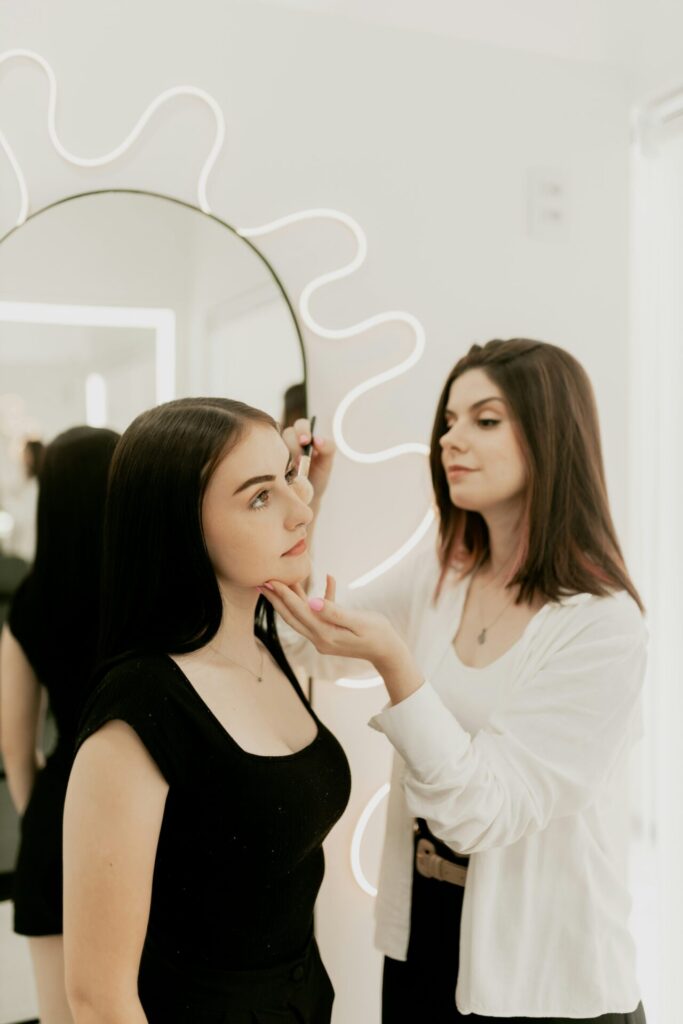 Makeup artist applying eyeliner to client