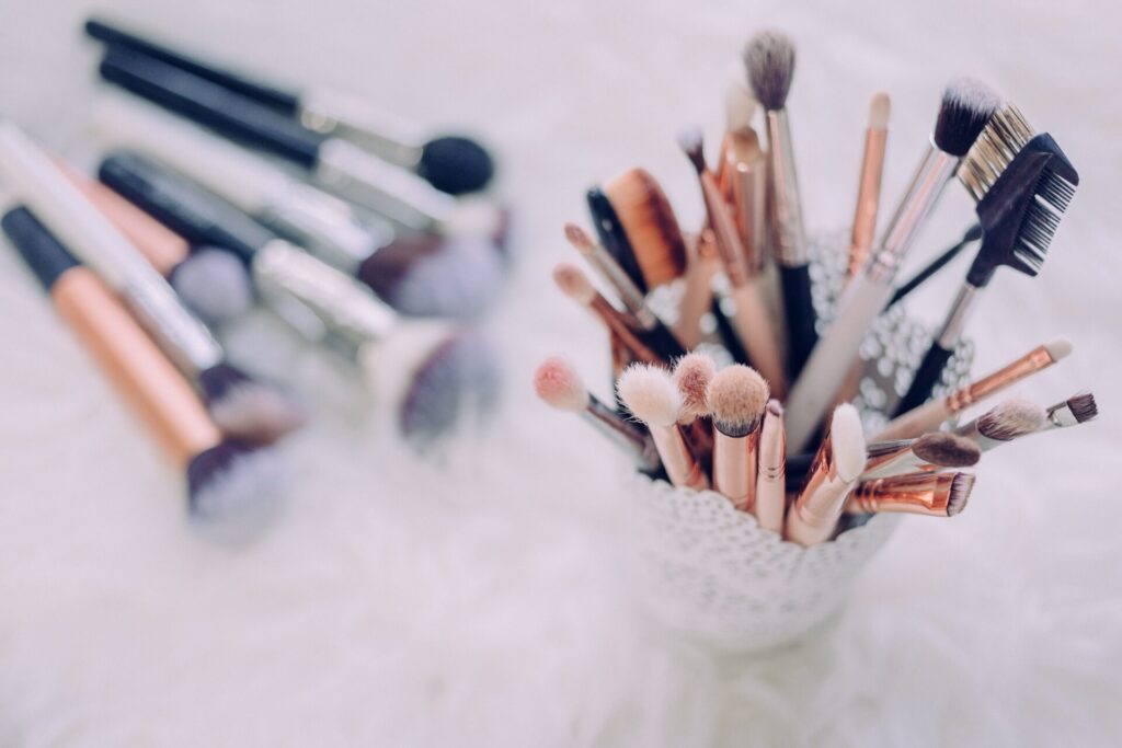 Assorted makeup brushes in a decorative holder.