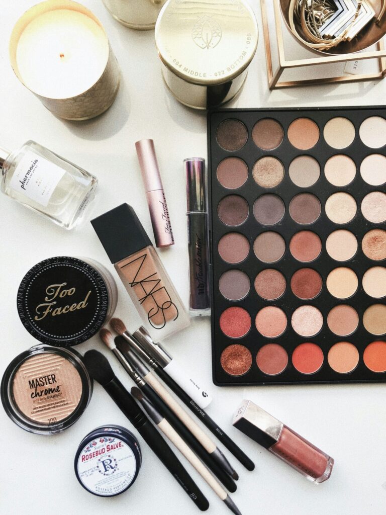 Assorted makeup products and brushes flat lay.