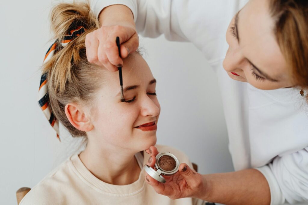 Makeup artist applying eyeshadow to woman