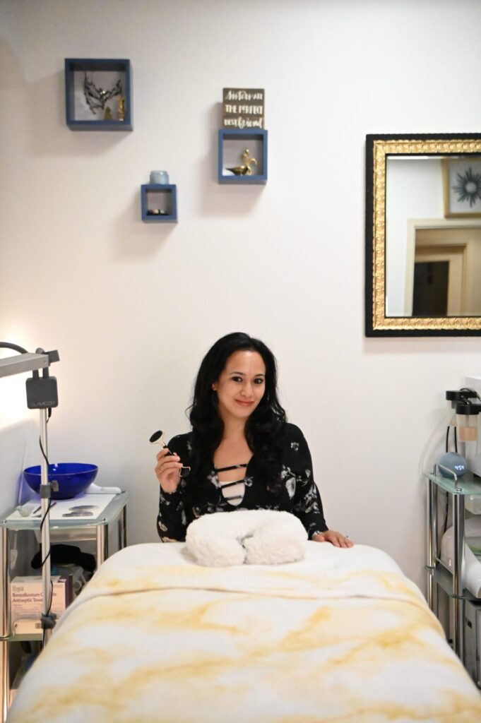 Esthetician holding jade roller in spa treatment room