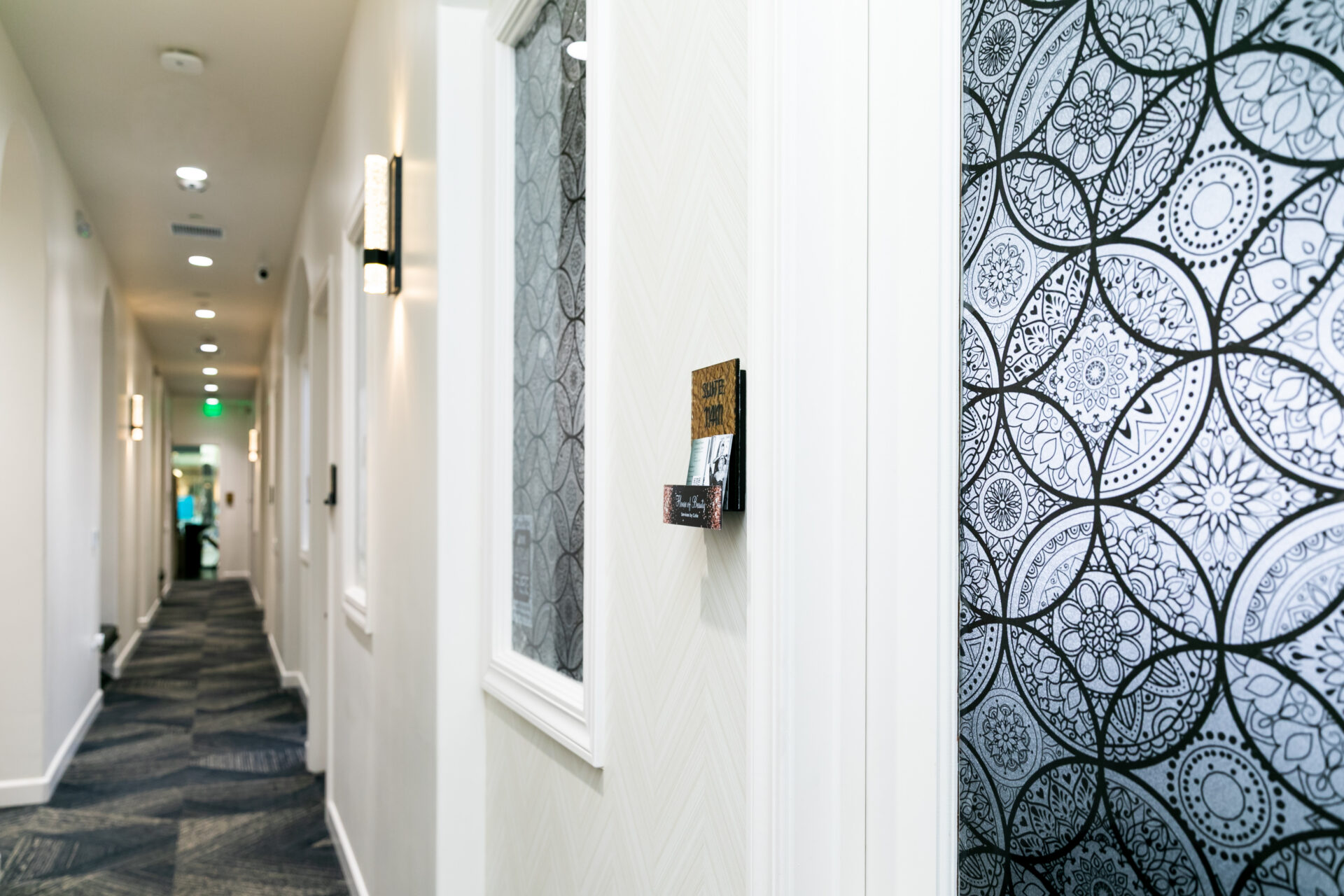 Modern salon suite hallway with patterned doors and wall sign