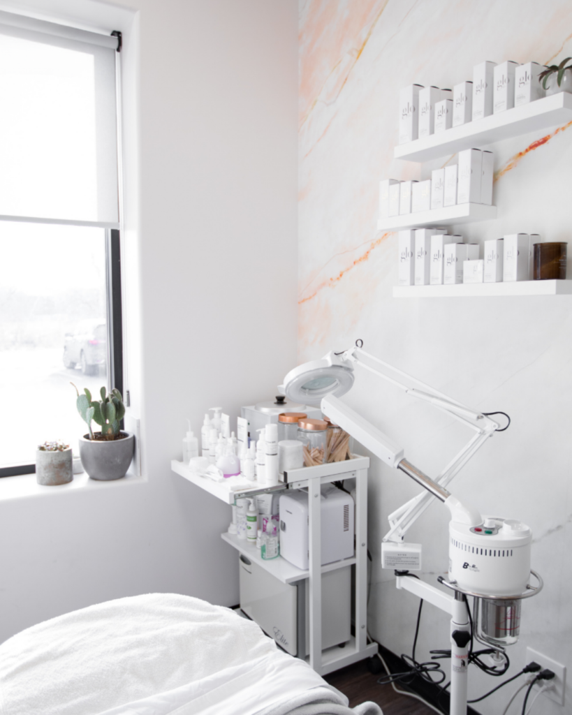 Minimalist spa treatment room with skincare shelves