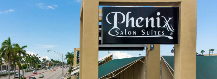 Phenix Salon Suites sign by palm-lined road